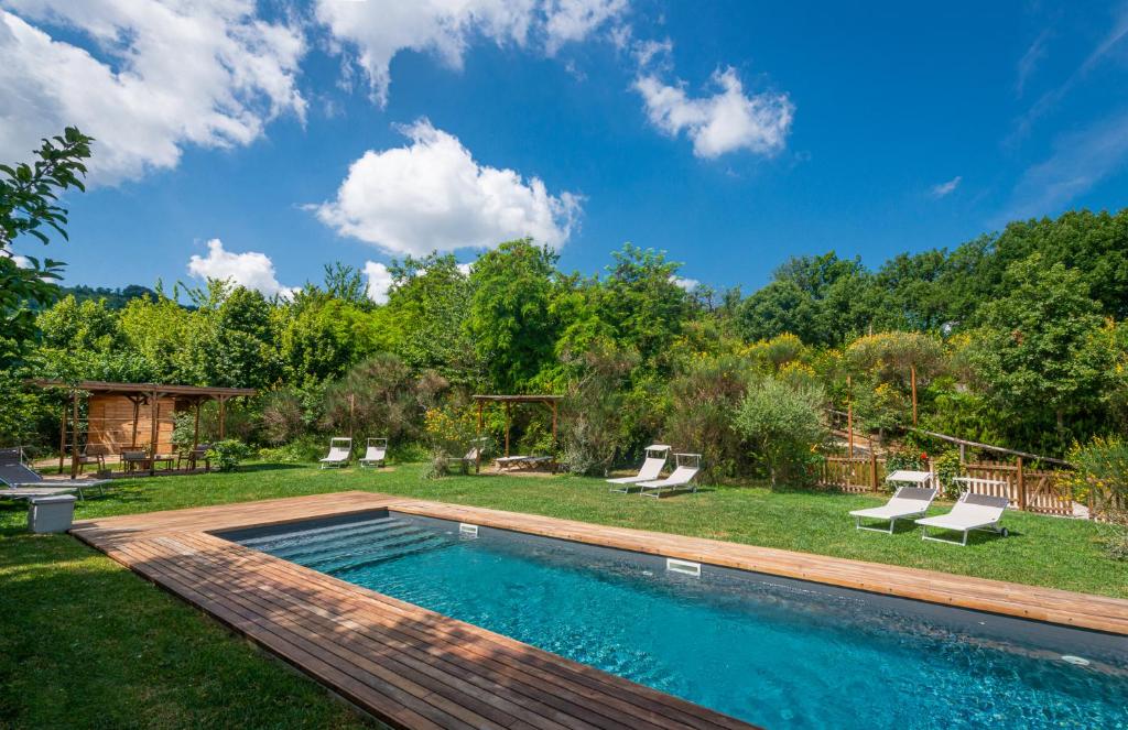 a swimming pool in a yard with chairs and trees at Casa Minotti Relais in Gubbio