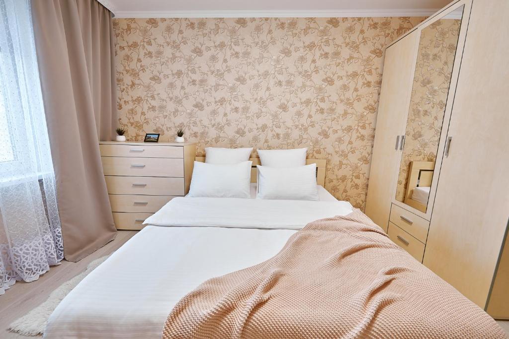 1 dormitorio con 2 camas y vestidor en PaulMarie Apartments on Yunosti, en Mazyr
