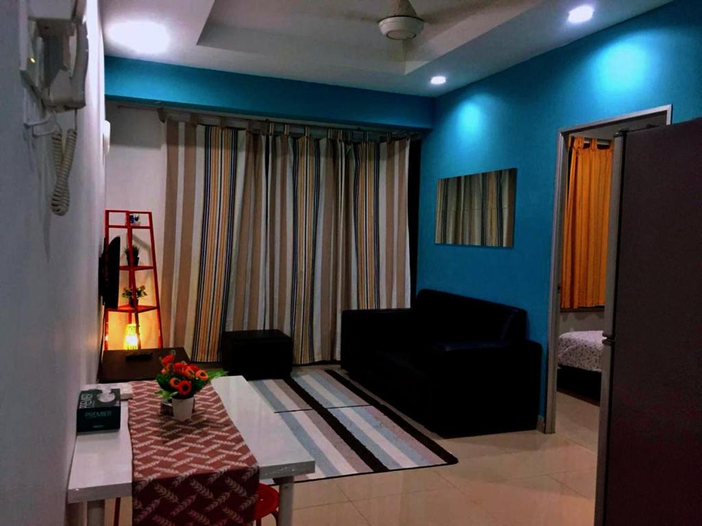 ein Wohnzimmer mit einem Sofa und einem Tisch in der Unterkunft Menara U Shah Alam Guest House in Shah Alam