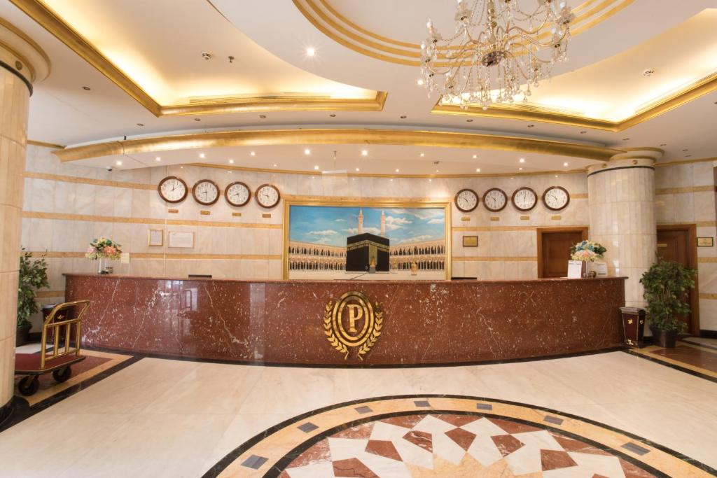 a lobby with a reception desk and a chandelier at Palestine Hotel Makkah in Makkah