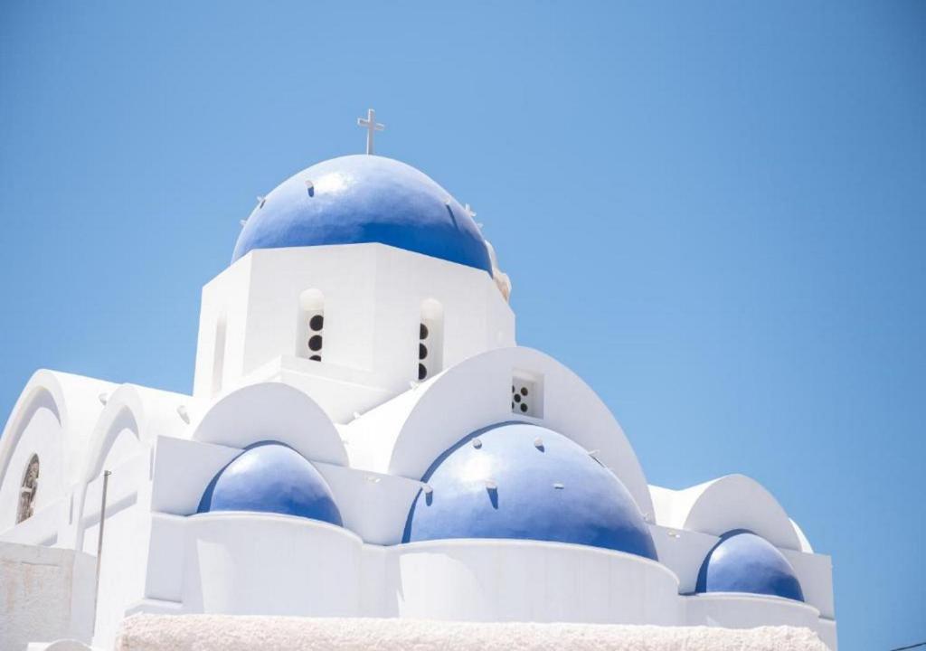 a white and blue building with a blue dome at Villa LuxL in Fira