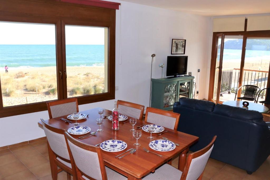ein Esszimmer mit einem Tisch und Meerblick in der Unterkunft Les Dunes Excelentes vistas a la Playa de Pals 318 in Begur