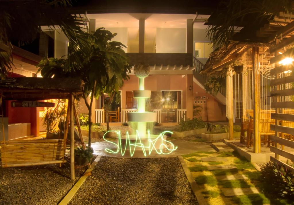 a building with a lit up sign in front of it at SMAK's Hotel in Bantayan Island