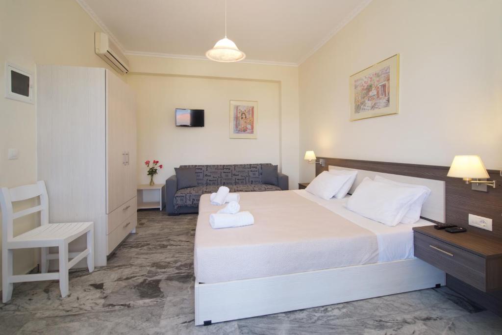 a bedroom with a large white bed and a chair at Prince Studios in Sami