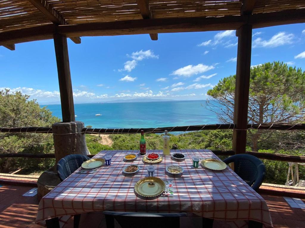 stół z jedzeniem i widokiem na ocean w obiekcie Villa San Marco - Casa esclusiva nel Sinis w mieście San Giovanni di Sinis