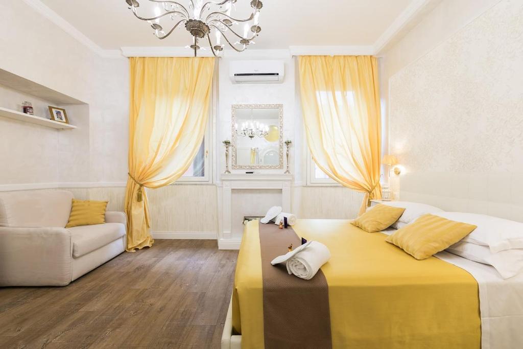 a bedroom with a yellow bed and a couch at Sweet Life Trevi Roma in Rome