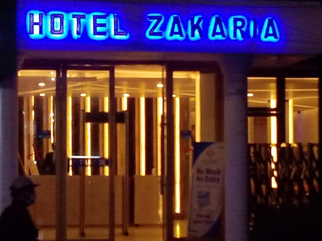 una señal de hotel zaria en la parte delantera de un edificio en Hotel Zakaria International en Dhaka