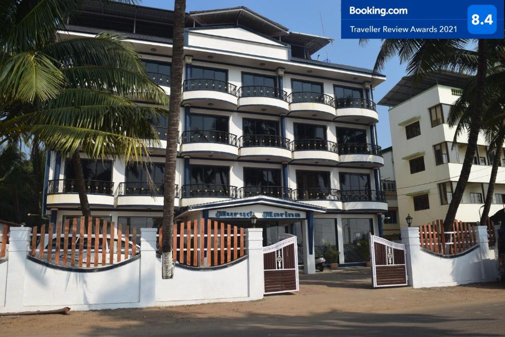 ein weißes Gebäude mit einer Palme davor in der Unterkunft Hotel Murud Marina in Murud