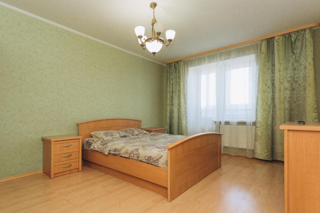 1 dormitorio con cama, ventana y lámpara de araña en Apartment in the Center, en Sumy