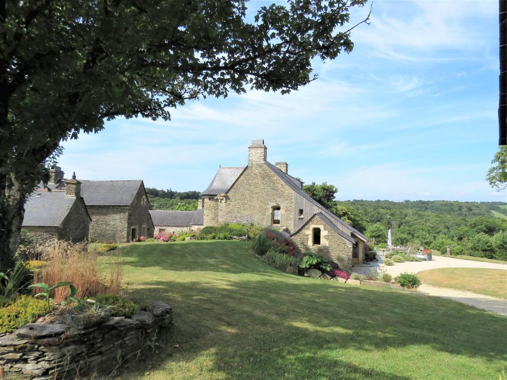 カレ・プルゲールにあるChambres d'hôtes, Zimmer, Domaine de Kervennecの緑の芝生の古石造りの家