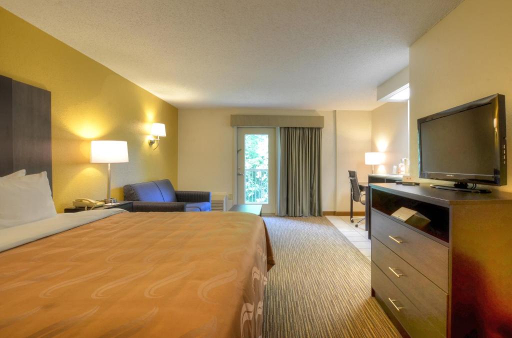 切諾基的住宿－切諾基品質酒店，配有一张床和一台平面电视的酒店客房