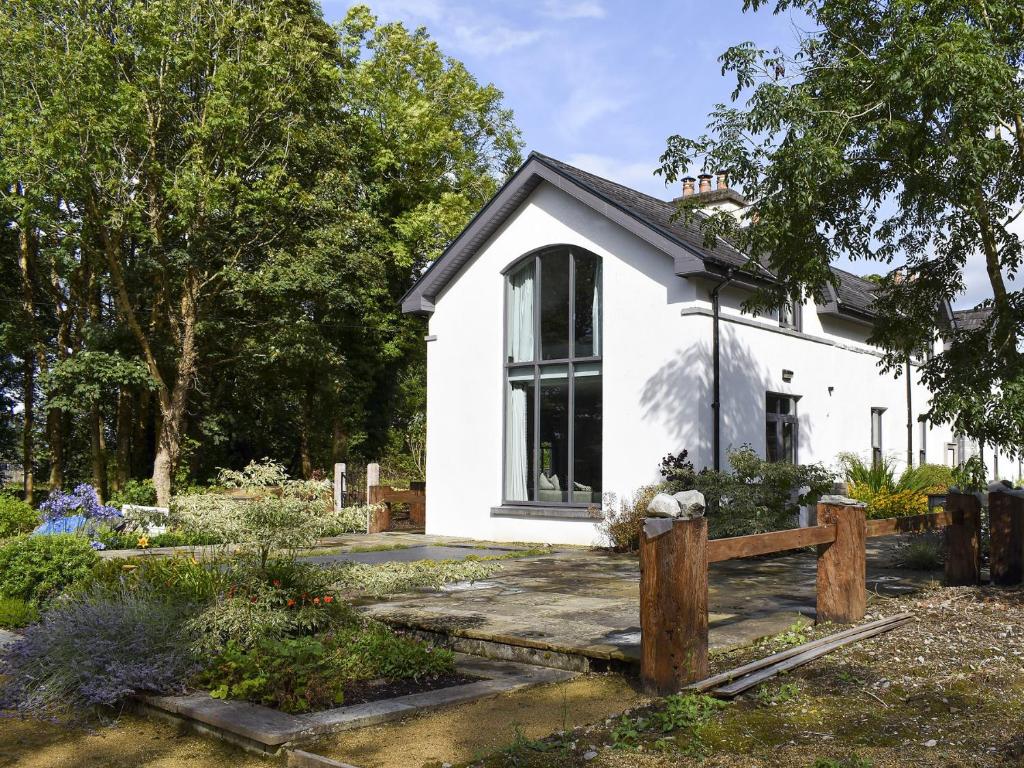 una casa blanca con un jardín delante de ella en Ballyquirke House en Moycullen