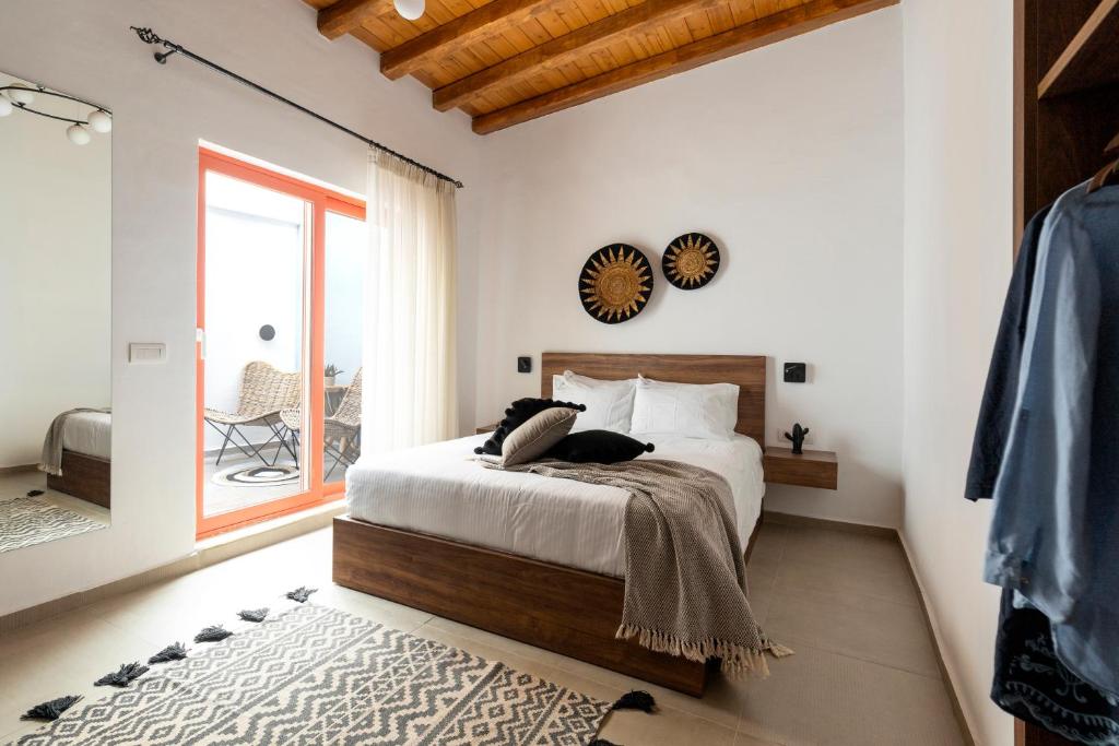 Schlafzimmer mit einem Bett und einem Fenster in der Unterkunft Blue Jasmine Suites in Rhodos (Stadt)