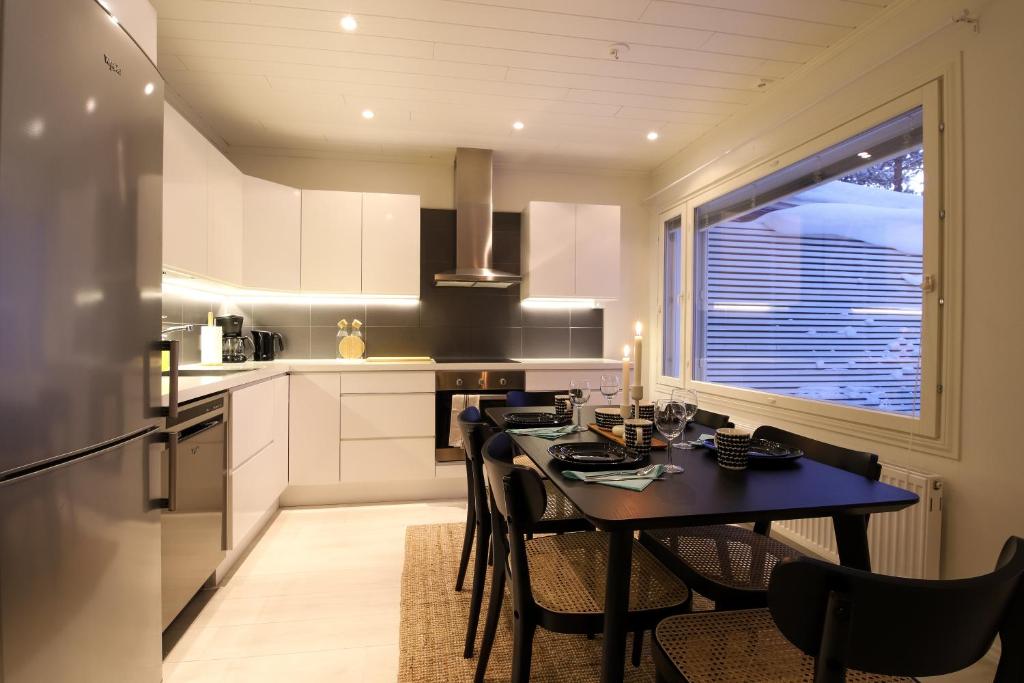 y cocina con mesa, sillas y nevera. en Arctic Circle Holiday Homes, en Rovaniemi