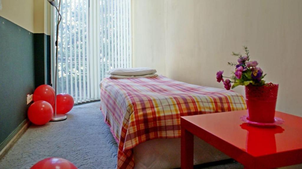 um quarto com uma cama e uma mesa com flores em Roof em Sochi