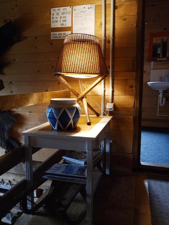 a lamp on a table with a bowl on it at Planinarski dom "Tornik" Zlatibor in Ribnica