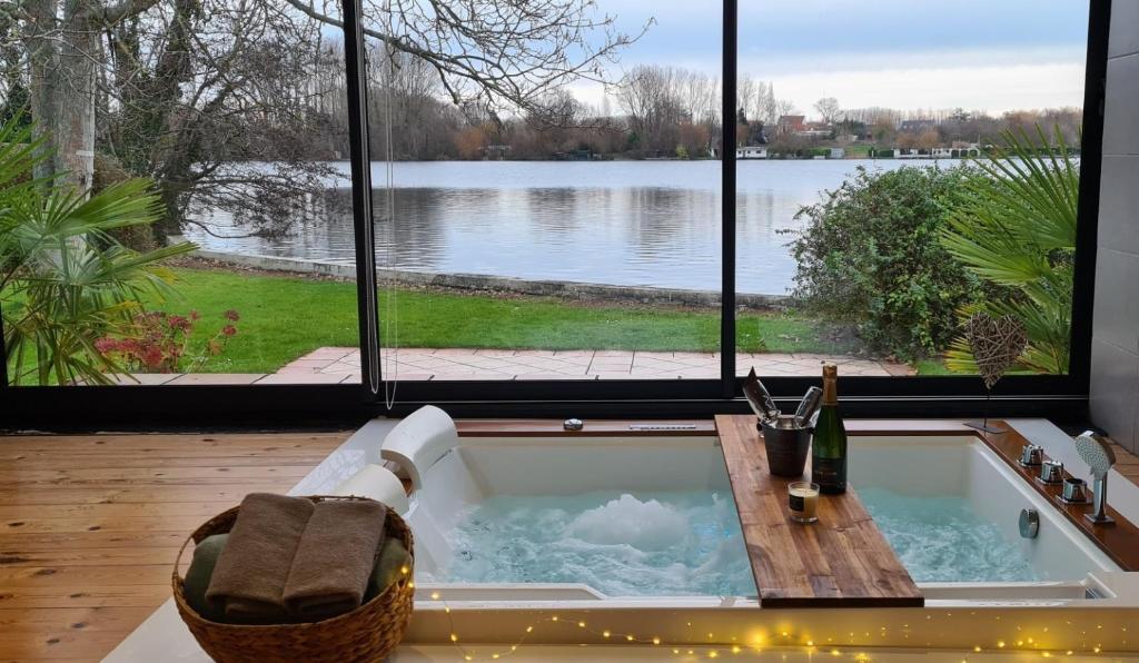 a bath tub with a view of a lake at Les Secrets du Lac in Ardres