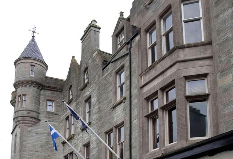 a castle with two flags flying in front of it at The Grand Hotel in Lerwick