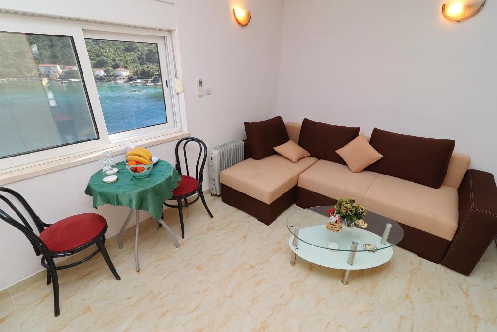 salon z kanapą i stołem w obiekcie Apartment Belin Mljet w mieście Okuklje