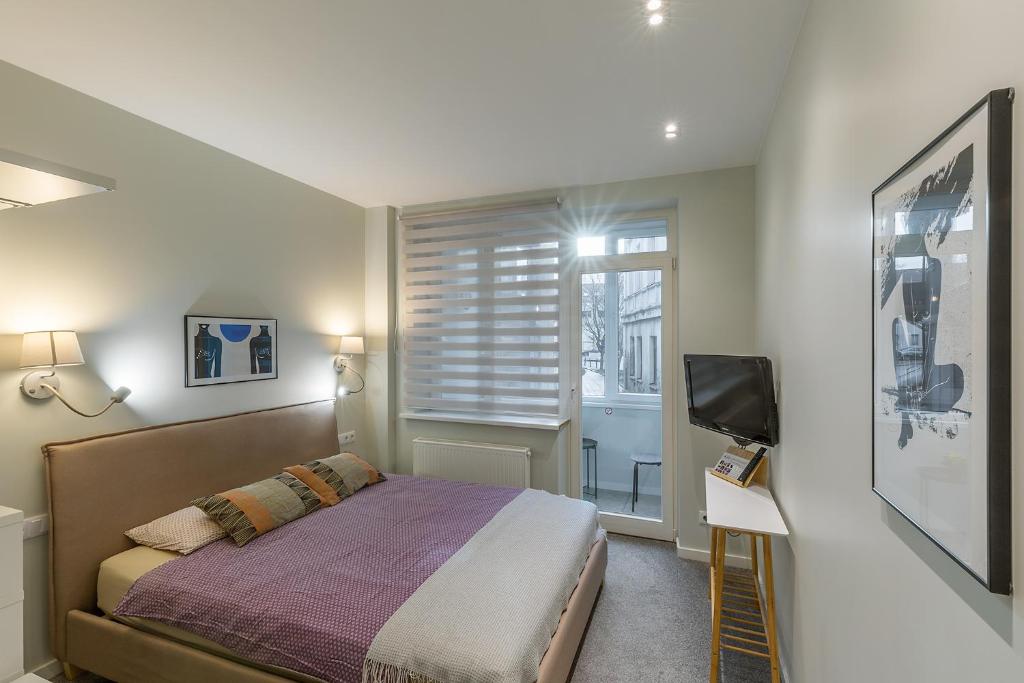 考納斯的住宿－Art & Comfort Rooms，一间卧室设有一张床、一台电视和一个窗口。