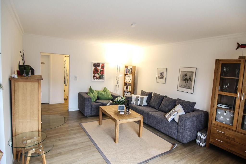 ein Wohnzimmer mit einem Sofa und einem Tisch in der Unterkunft Ferienwohnung Blaue Huis Erdgeschoß in Wenningstedt-Braderup