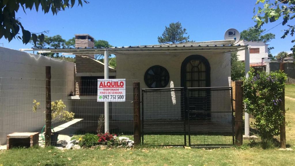 a house with a sign in front of a gate at Casa en Alquiler in Piriápolis