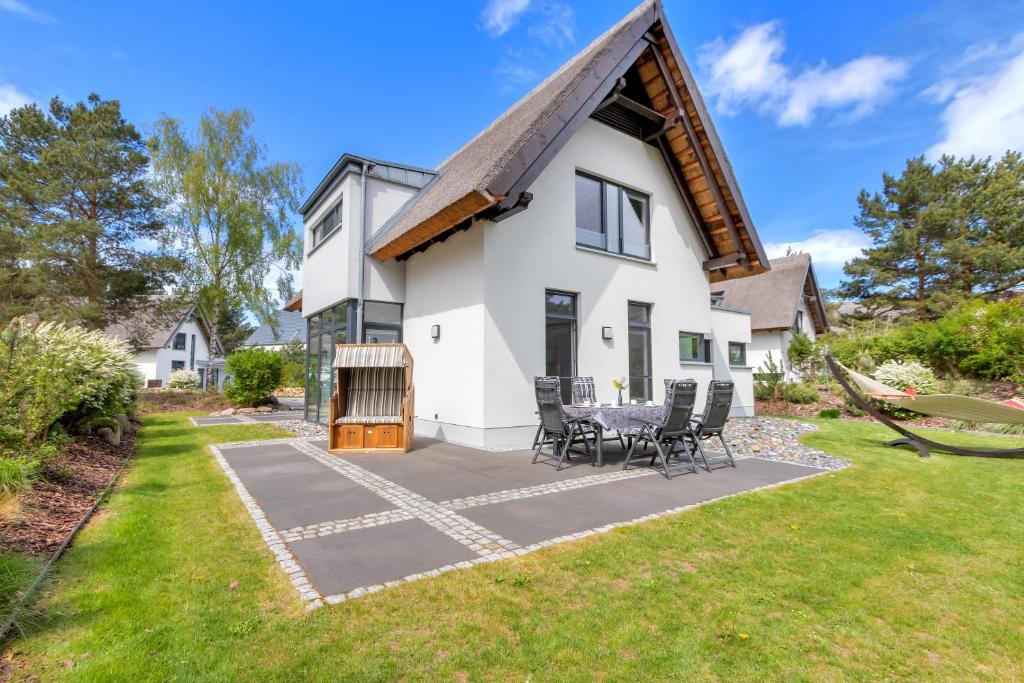 a white house with a patio and grass at Seeperle in Ostseebad Karlshagen