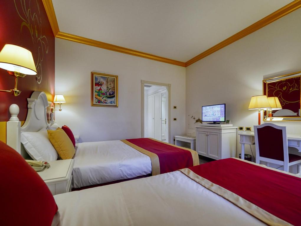 Postel nebo postele na pokoji v ubytování Gardaland Hotel