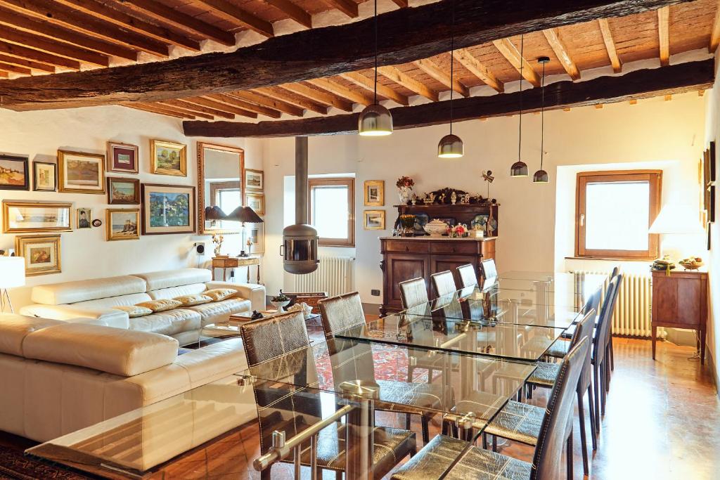 a dining room and living room with a glass table at La Casa Di Adelina in Monticchiello