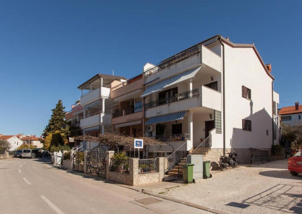 ein weißes Gebäude an der Straßenseite in der Unterkunft Apartments Ivo Rovinj Croatia in Rovinj