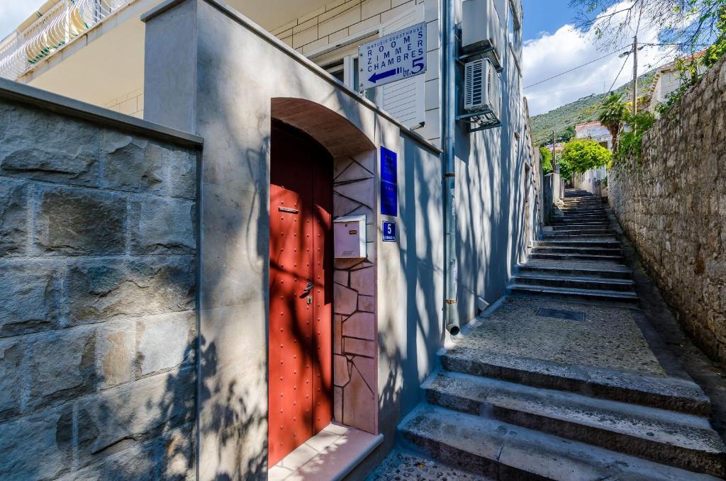 eine Gasse mit einer roten Tür in einem Gebäude in der Unterkunft Guesthouse Matusic in Dubrovnik