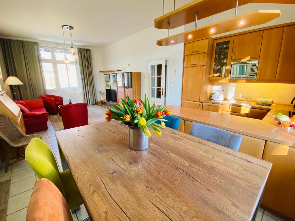 eine Küche mit einem Holztisch mit einer Vase mit Blumen darauf in der Unterkunft Villa Caprivi - 6 in Heringsdorf