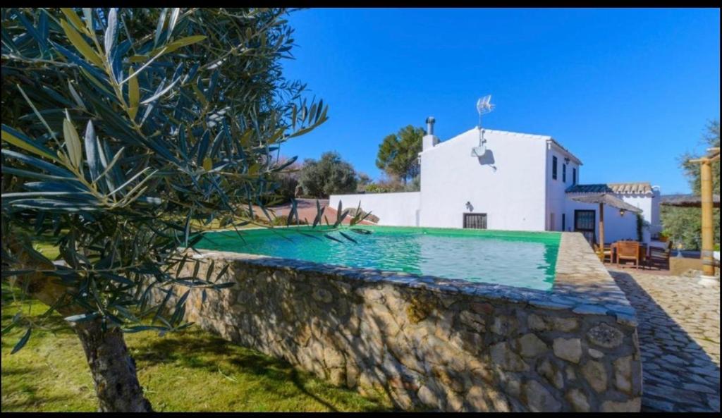 una piscina frente a un edificio blanco en El Puente, en Ronda