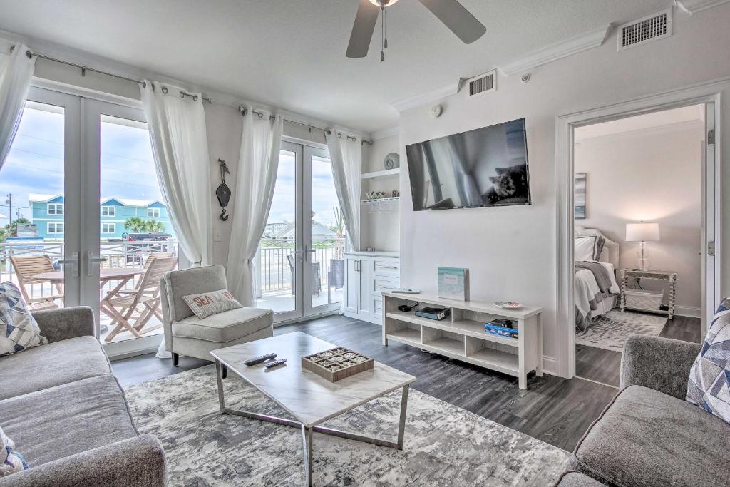 a living room with a couch and a tv at Dazzling Mexico Beach Condo - Walk to the Beach! in Mexico Beach