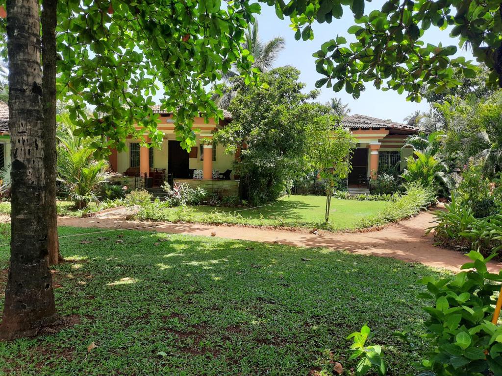 a house in the middle of a yard at Tobias Villas in Cavelossim