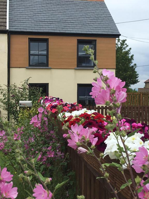 a fence with flowers in front of a house at Willow Mews in Swansea