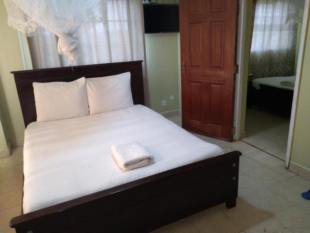 a bed with a white towel on top of it at Crown Hotel Kericho in Kericho