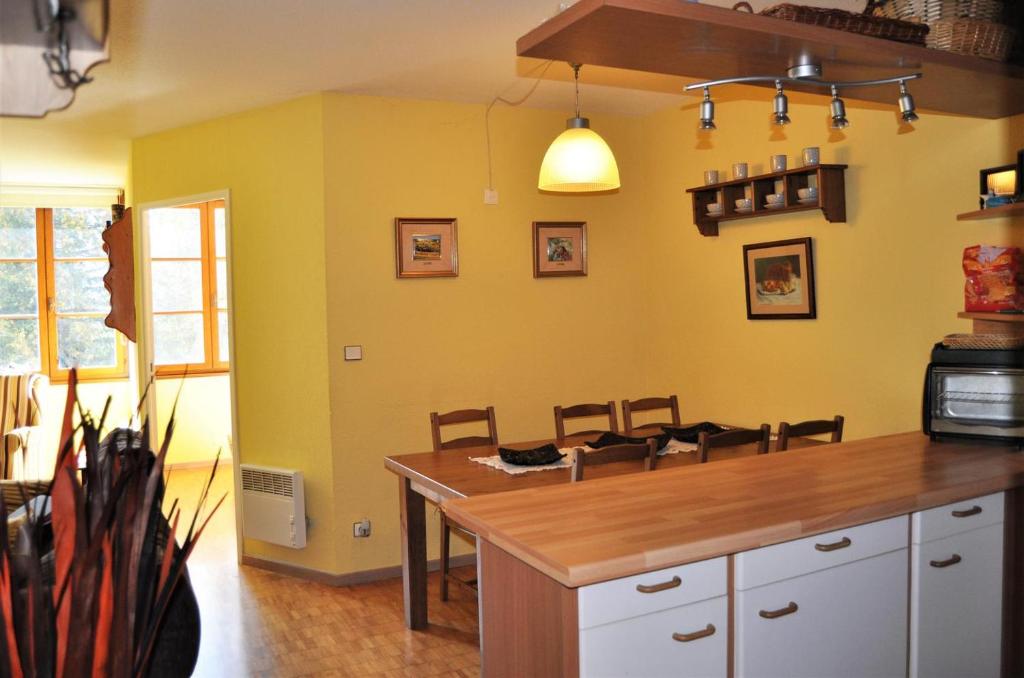 a kitchen with yellow walls and a wooden counter top at Apartamento con piscina en Enveitg in Enveitg