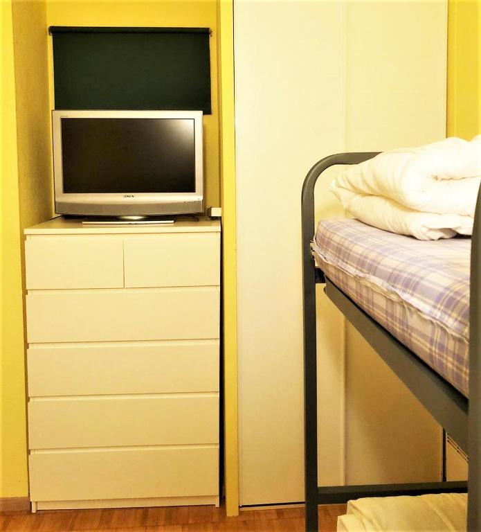 a bedroom with a bed and a television on a dresser at Apartamento con piscina en Enveitg in Enveitg