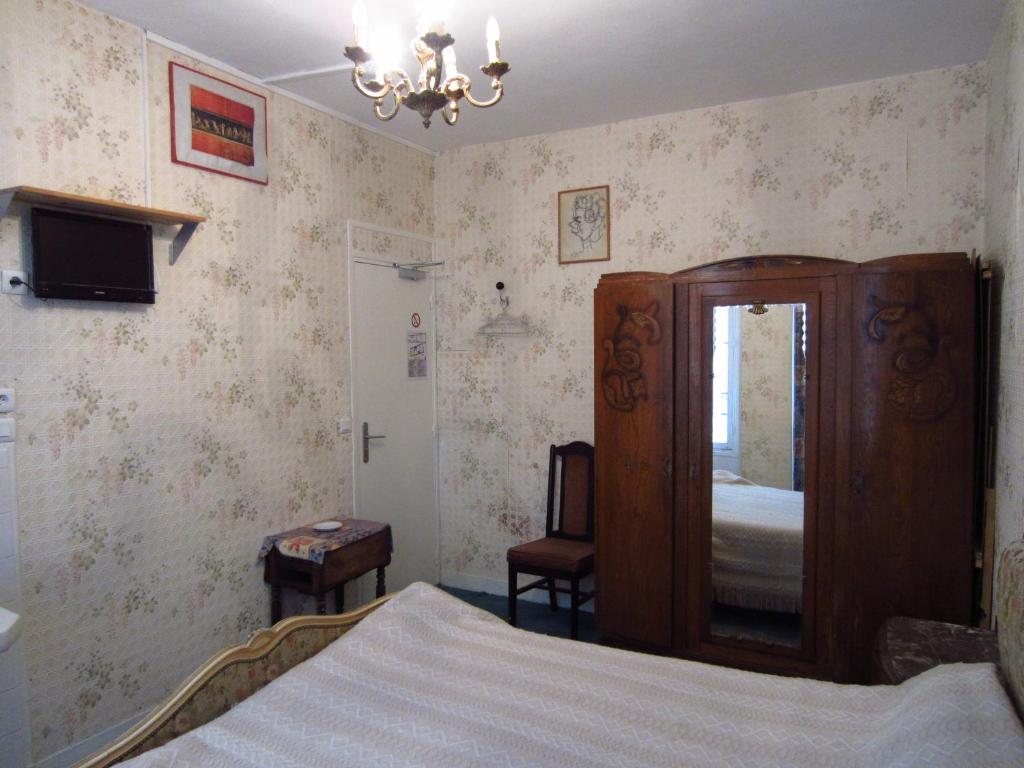 - une chambre avec un lit, une commode et un miroir dans l'établissement Hotel d'Orléans Paris Gare de l'Est, à Paris