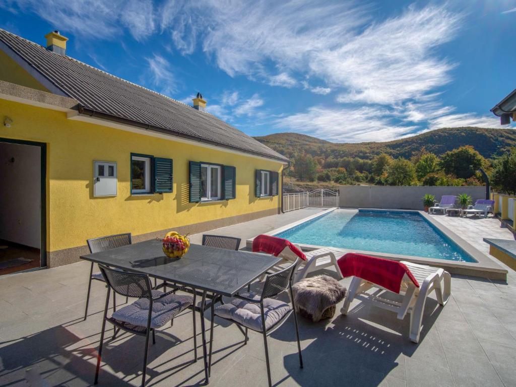 a patio with a table and chairs and a pool at Holiday Home Saulja by Interhome in Sveti Juraj