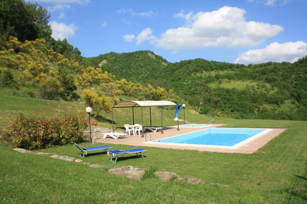 una piscina con cenador junto a una colina en Agriturismo Sacchiafarm, en Borgo Pace