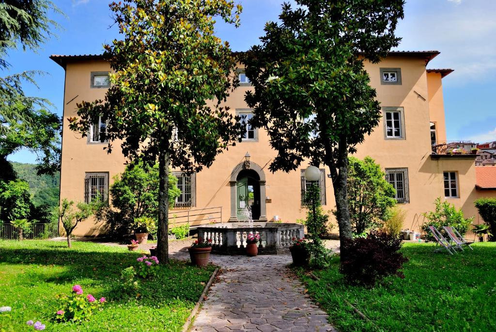 a large stone building with a bench in front of it at Villa Gherardi - B&B e Hostel in Barga