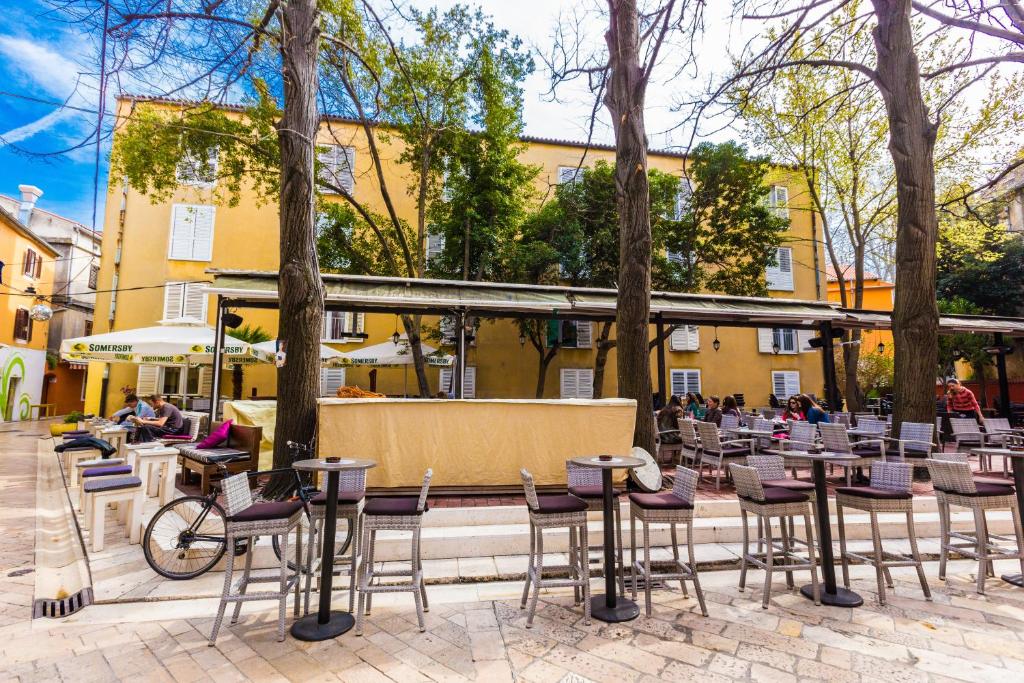 patio z krzesłami i stołami oraz budynek w obiekcie Dispetto apartment in old city w mieście Zadar