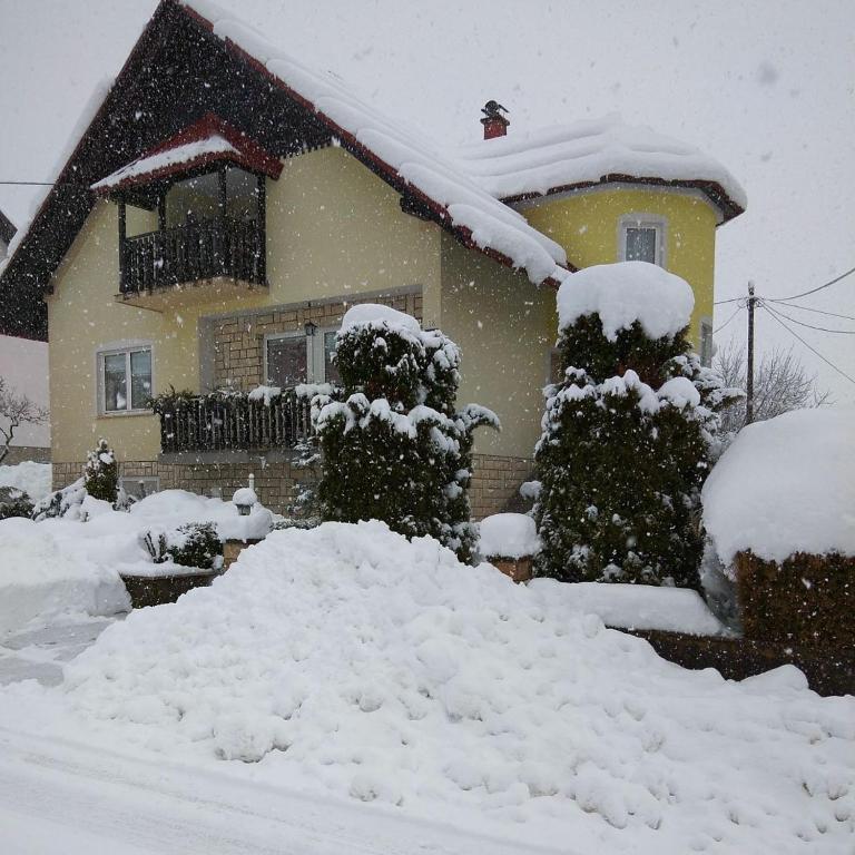 una casa con un montón de nieve delante de ella en Apartment Petra en Mrkopalj