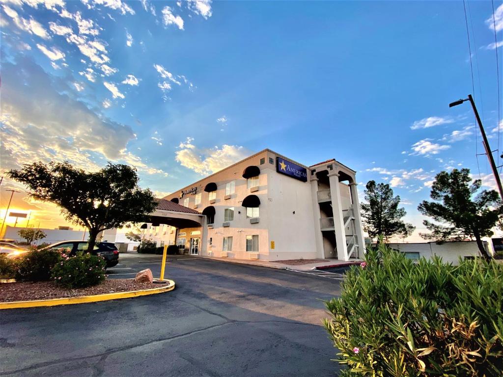 a building with a ramp in a parking lot at Americas Hotel - El Paso Airport / Medical Center in El Paso