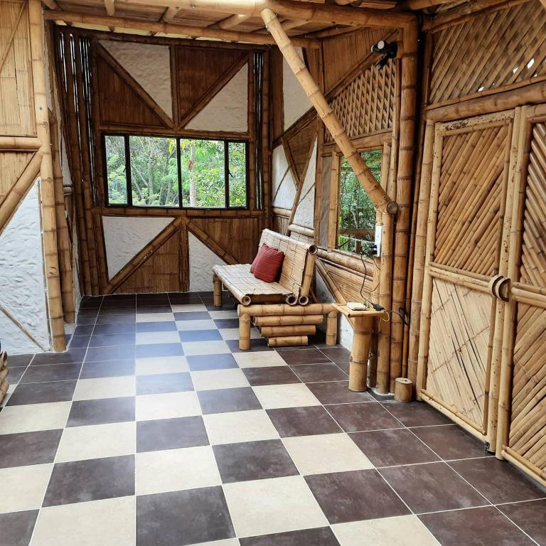 a room with a checkered floor in a wooden cabin at Colibamboo Ecolodge Biocasa artesanal rodeada de naturaleza con jaccuzi y mucho más in Pacho
