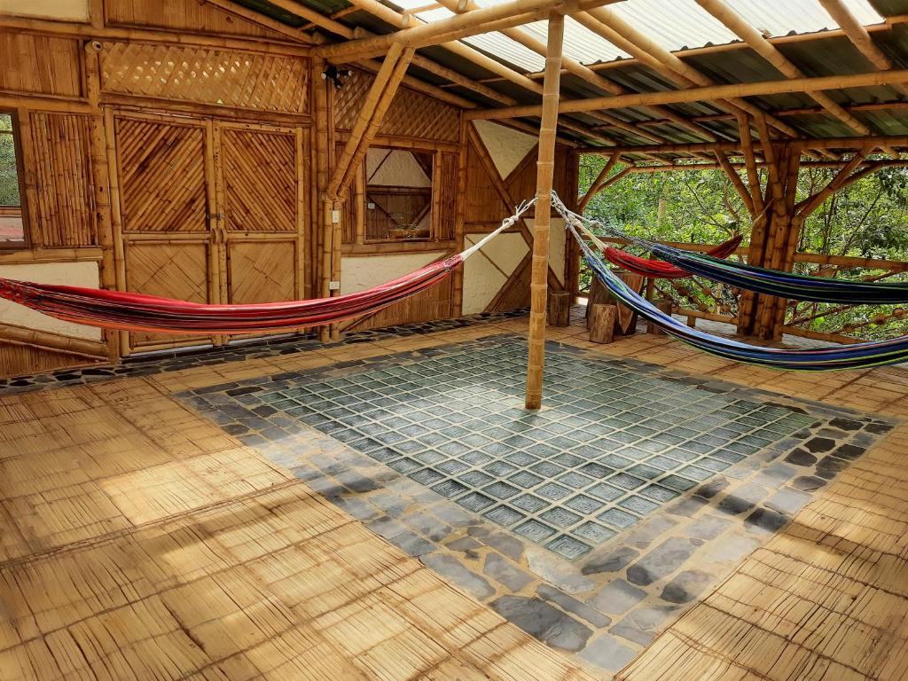 a room with a hammock in a house at Colibamboo Ecolodge Biocasa artesanal rodeada de naturaleza con jaccuzi y mucho más in Pacho