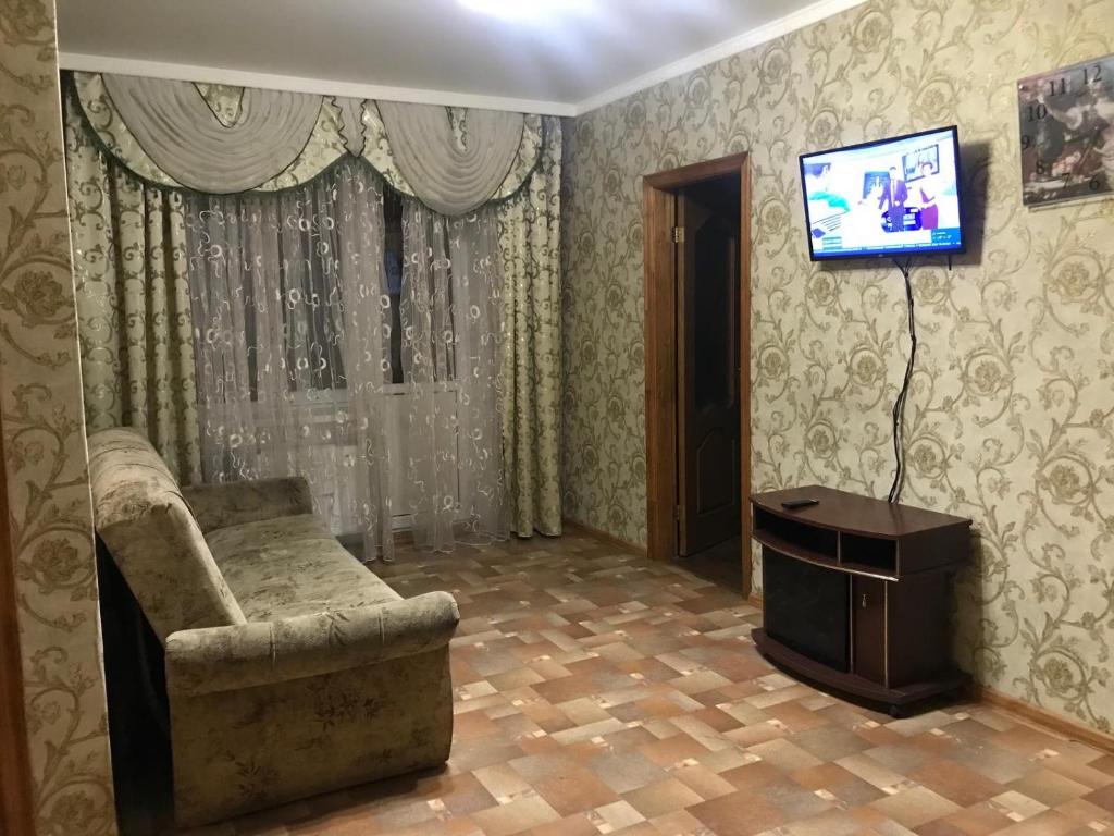 a living room with a couch and a flat screen tv at Shevchenka Guest House от 600гр 1-2-3к квартири 096-55-48-111 біля Академії in Khmelnytskyi