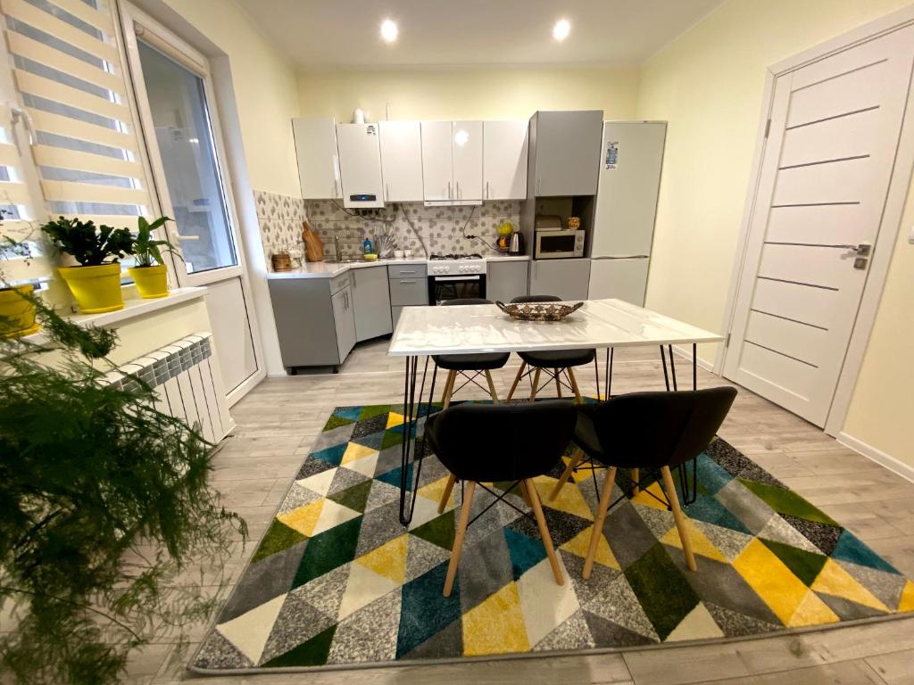 a kitchen with a table and chairs on a rug at Чотири стихії in Mizhhirʼʼya